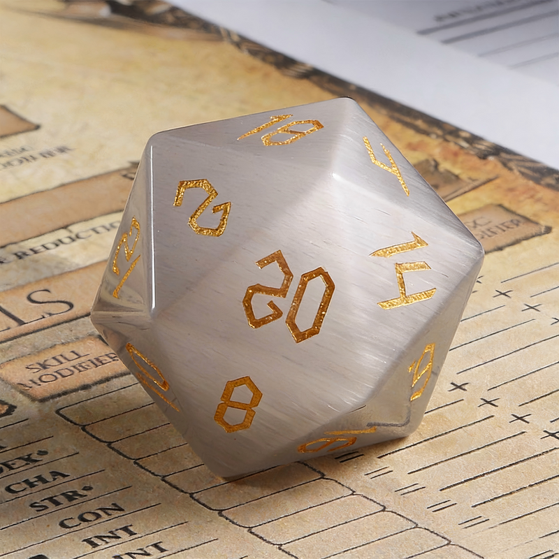 Close-up of grey cat's eye crystal D20 showing light band effect — tabletop RPG dice