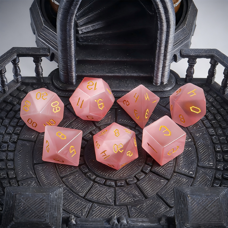 Close-up of pink cat's eye crystal D20 showing light band effect — tabletop RPG dice