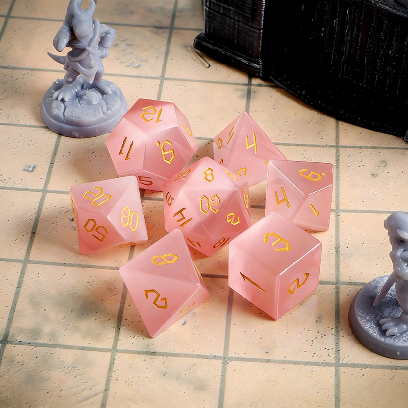 7-piece cat's eye stone DND dice set — soft rose pink with warm white chatoyant line with chatoyant shimmer