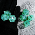 Close-up of translucent seafoam green with opalescent shimmer crystal D20 for Dungeons and Dragons
