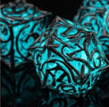 7-piece metal DND dice set — dark metal with cyan glow-in-the-dark fill