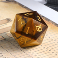 7-piece cat's eye stone DND dice set — warm golden-brown with amber chatoyant bands with chatoyant shimmer